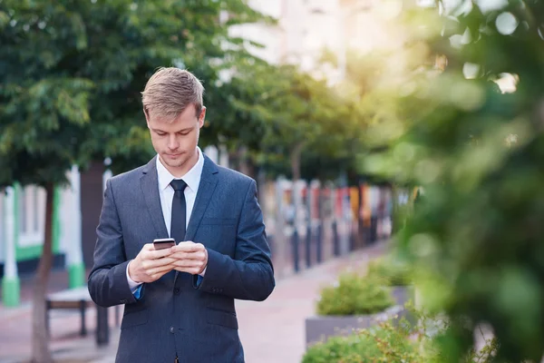 Hombre de negocios enviar mensaje de texto en el teléfono celular — Foto de Stock
