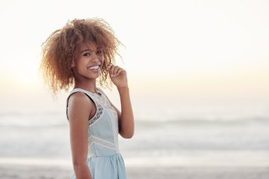 Gün batımında sahilde duran kadın.