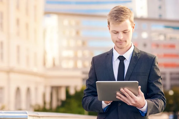 Empresário usando tablet digital com cidade — Fotografia de Stock