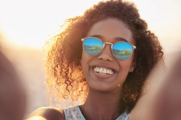 Žena nosí sluneční brýle na pláži — Stock fotografie