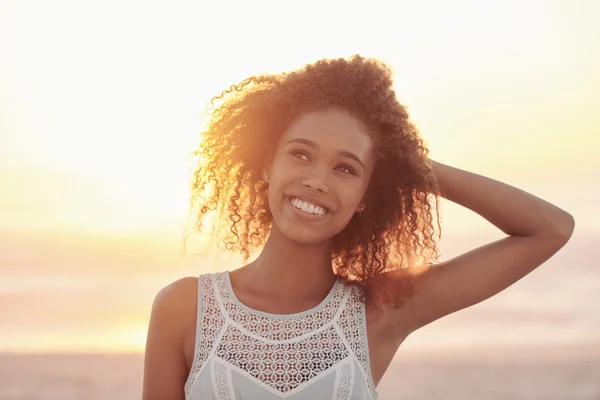 Mulher com as mãos no cabelo na praia ao pôr do sol — Fotografia de Stock