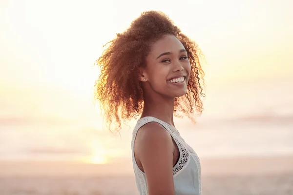 Mujer de pie en la playa al atardecer — Foto de Stock