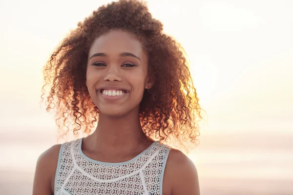 Mujer de pie en la playa al atardecer — Foto de Stock