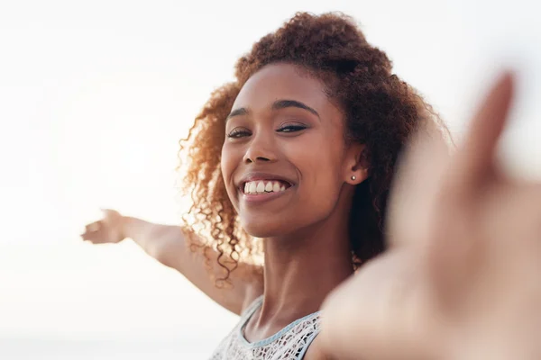 Woman standing on beach with arms raised — Stock Photo, Image