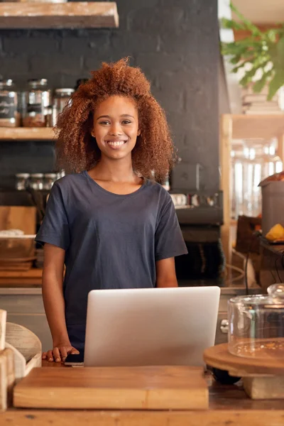 Mujer usando el ordenador portátil mientras trabaja en la cafetería — Foto de Stock