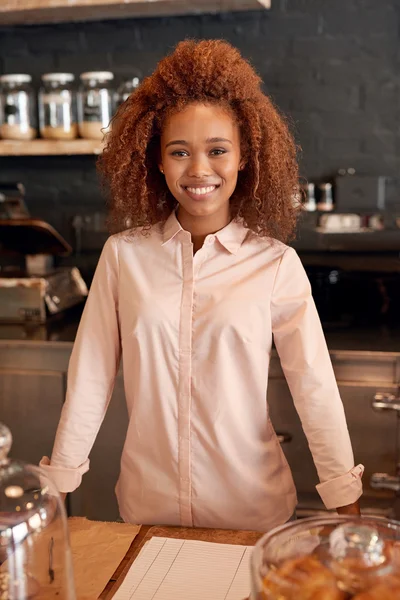 Woman standing behind counter of cafe — Stock Photo, Image