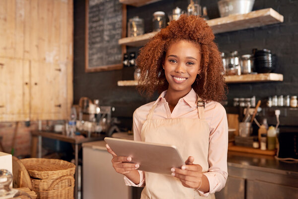 woman using tablet while working in cafe