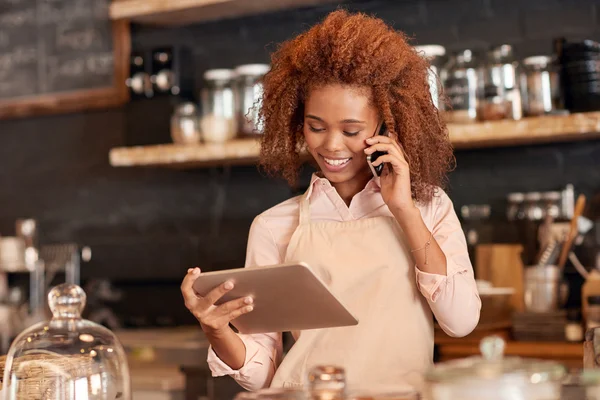 Mujer usando la tableta y hablando por teléfono — Foto de Stock