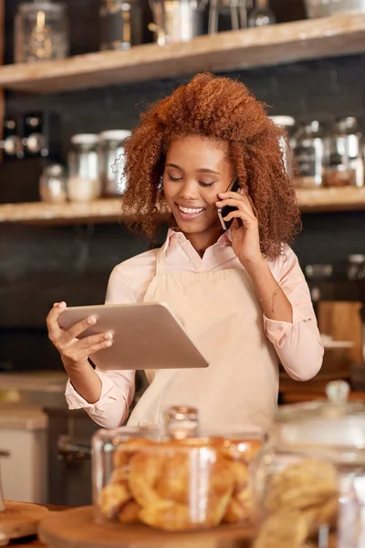 Frau benutzt Tablet und telefoniert — Stockfoto