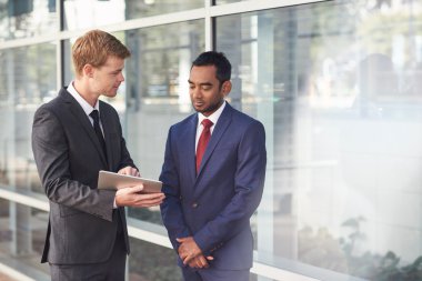 İşadamları birlikte dijital tablet üzerinde konuşuyor