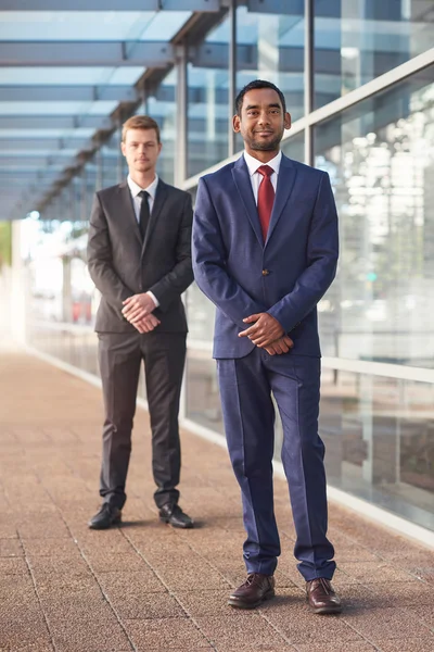 Businessmen standing in front of office building — Stock Photo, Image