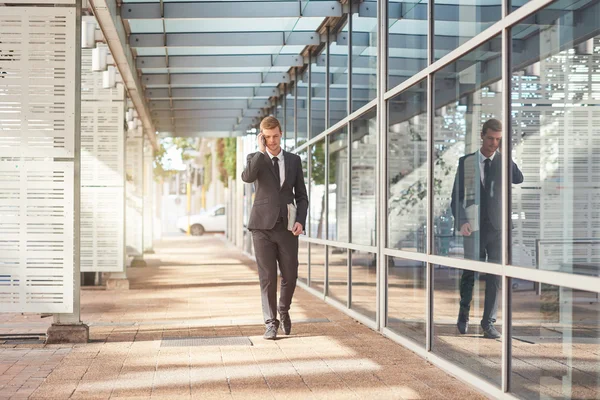 Empresário falando no celular enquanto caminha — Fotografia de Stock