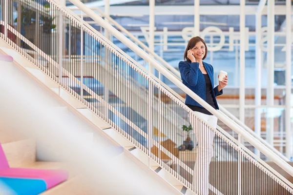 Donna d'affari su scale in ufficio moderno con telefono — Foto Stock