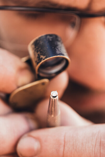 jeweler using loupe to examine diamond