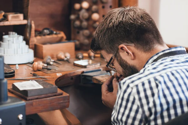 Juwelier untersucht Schmuckstück mit Lupe — Stockfoto