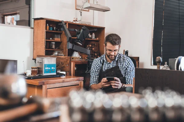 Juwelier met behulp van mobiele telefoon tijdens de vergadering op de Bank — Stockfoto