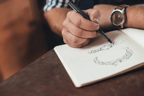 Jeweler sketching out new jewelry designs — Stock Photo, Image