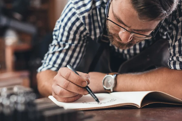 Juwelier schetsen van sieraden ontwerpt in notebook — Stockfoto