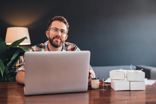 Предприниматель сидит за столом с помощью ноутбука — стоковое фото