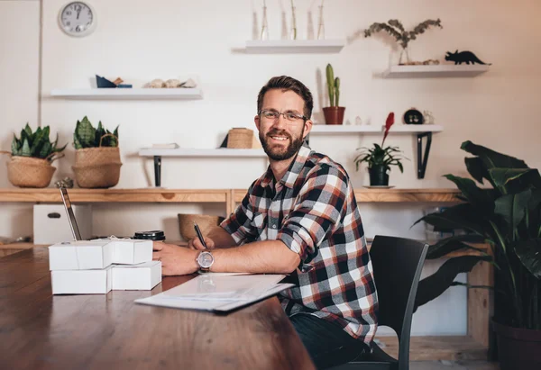 Entreprenör som sitter vid bord med laptop — Stockfoto