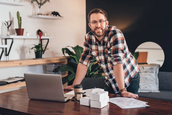 Empreendedor inclinado sobre a mesa em casa — Fotografia de Stock