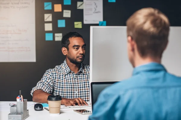 Ontwerper zit aan bureau werkt op computer — Stockfoto