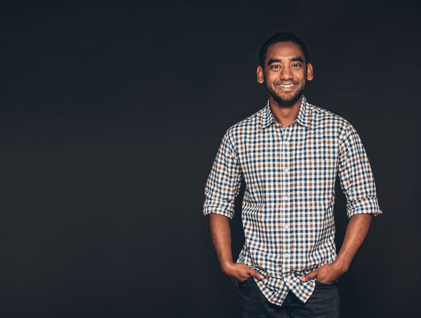 предприниматель, стоящий с руками в карманах
