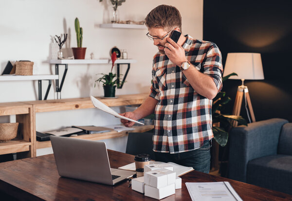 entrepreneur  talking on cellphone and reading paperwork