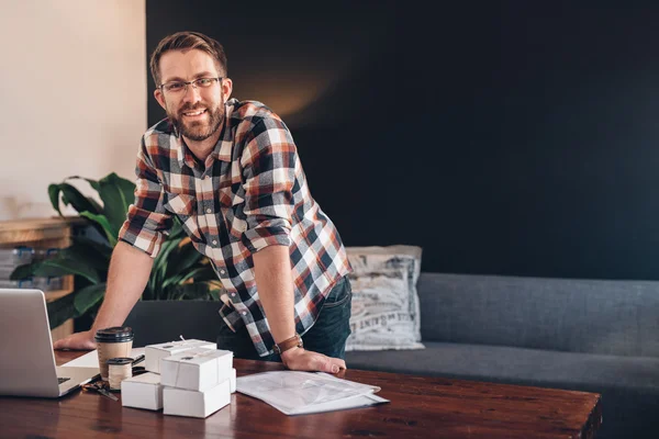 Ondernemer leunend op tafel thuis — Stockfoto