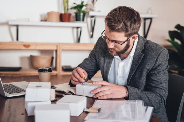 entrepreneur stamping seal on packages for delivery