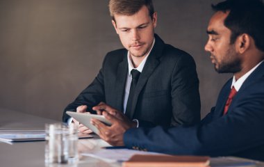 İşadamları birlikte dijital tablet üzerinde konuşuyor