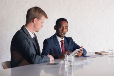 İşadamları birlikte dijital tablet üzerinde konuşuyor