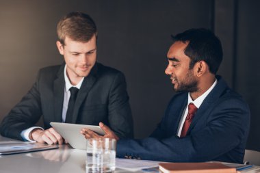 İşadamları birlikte dijital tablet üzerinde konuşuyor