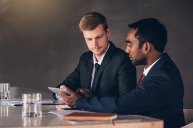 İşadamları birlikte dijital tablet üzerinde konuşuyor