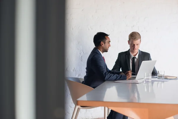 Homens de negócios em ternos conversando juntos por laptop — Fotografia de Stock