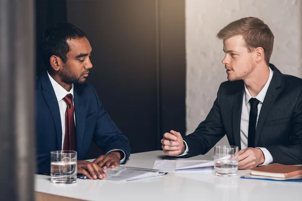 Homens de negócios discutindo documentos juntos à mesa — Fotografia de Stock