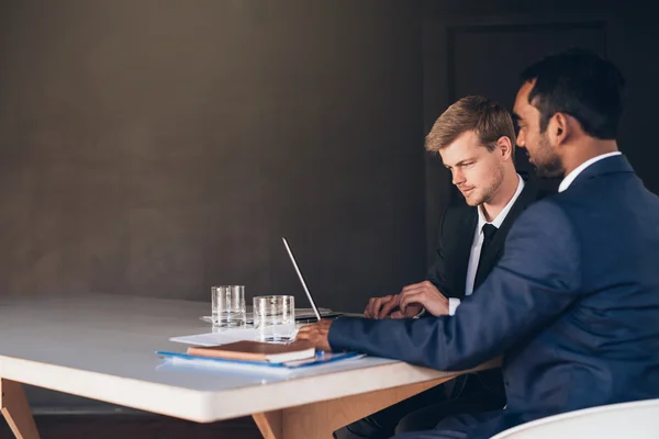 Homens de negócios em ternos conversando juntos por laptop — Fotografia de Stock