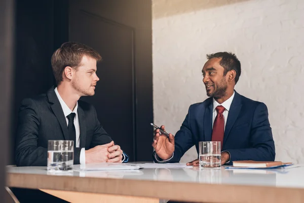 Hommes d'affaires discutant de documents ensemble à table — Photo