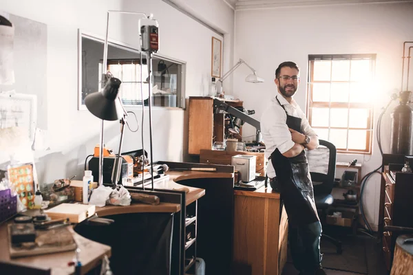 Jeweler standing in workshop full of tools — Stock Photo, Image