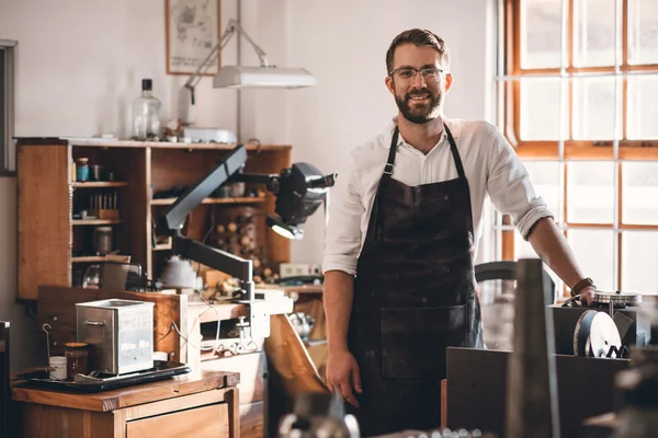 Gioielliere in piedi in officina pieno di attrezzi — Foto Stock