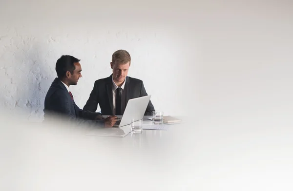 Бізнесмени в костюмах розмовляють разом через ноутбук — стокове фото