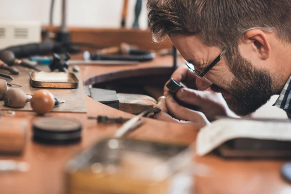 Joalheiro usando lupa para examinar o anel — Fotografia de Stock