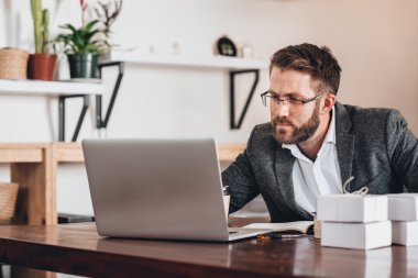 masada otururken dizüstü bilgisayarda çalışan girişimci
