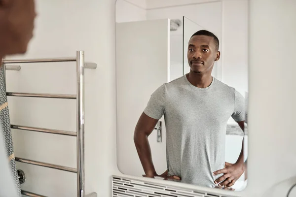一个自信的非洲年轻人站在浴室的镜子前 双手放在臀部上 — 图库照片
