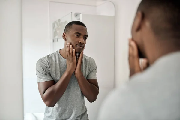 Ung Afrikansk Man Rör Sitt Ansikte Med Händerna Badrumsspegeln Morgonen — Stockfoto