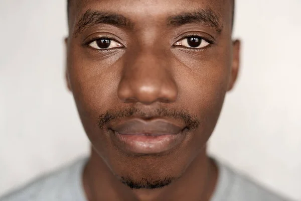 一名身穿T恤衫 自信的年轻非洲男子站在家中墙前的画像 — 图库照片