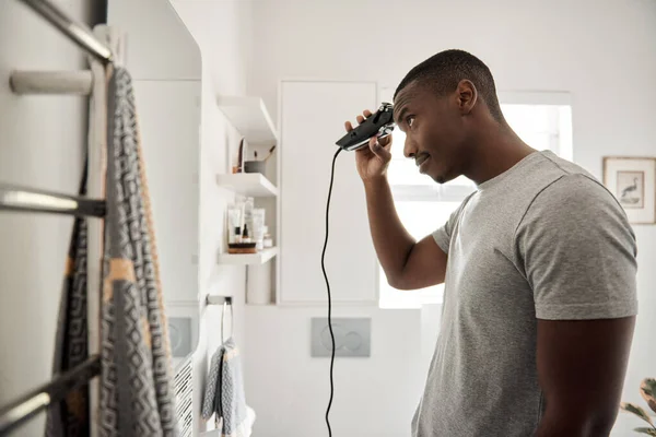 Joven Africano Cortándose Pelo Con Unas Tijeras Eléctricas Mientras Está — Foto de Stock