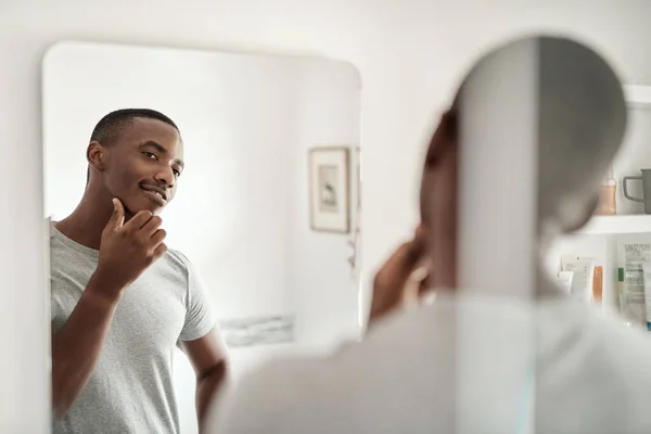 Leende Ung Afrikansk Man Vidrör Sitt Ansikte Med Handen Badrumsspegeln — Stockfoto