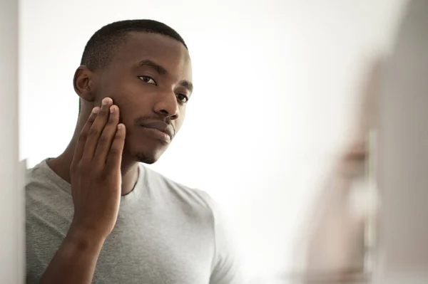 Joven Africano Pie Frente Espejo Baño Por Mañana Tocándose Mejilla — Foto de Stock