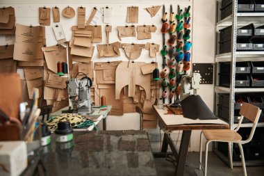 Sewing machines and an assortment of tools and materials inside of a boutique leather studio clipart
